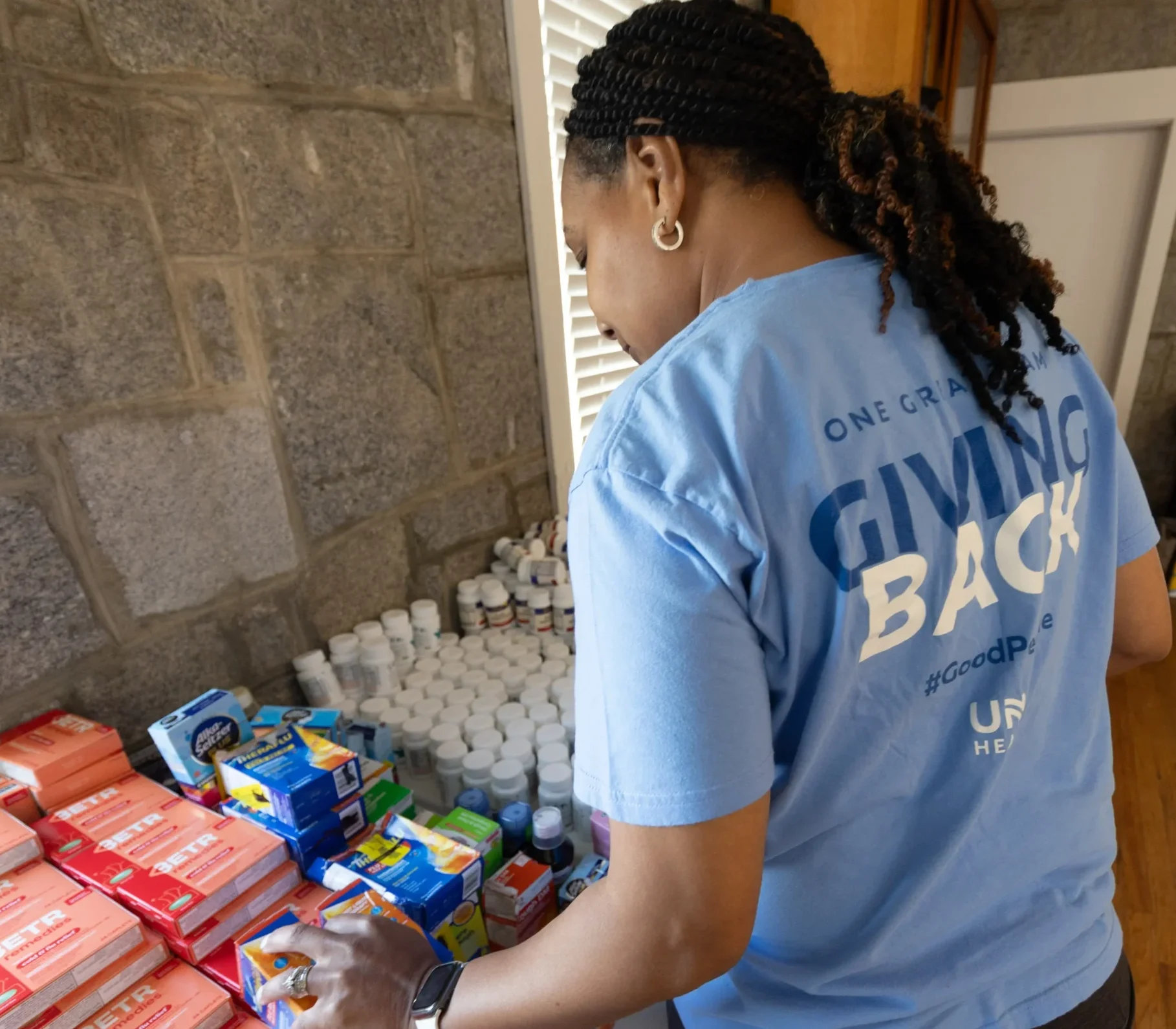 UNC Health volunteer organizes over-the-counter medications and healthcare supplies during a community outreach event supporting local residents, made possible by gifts from donor-advised funds