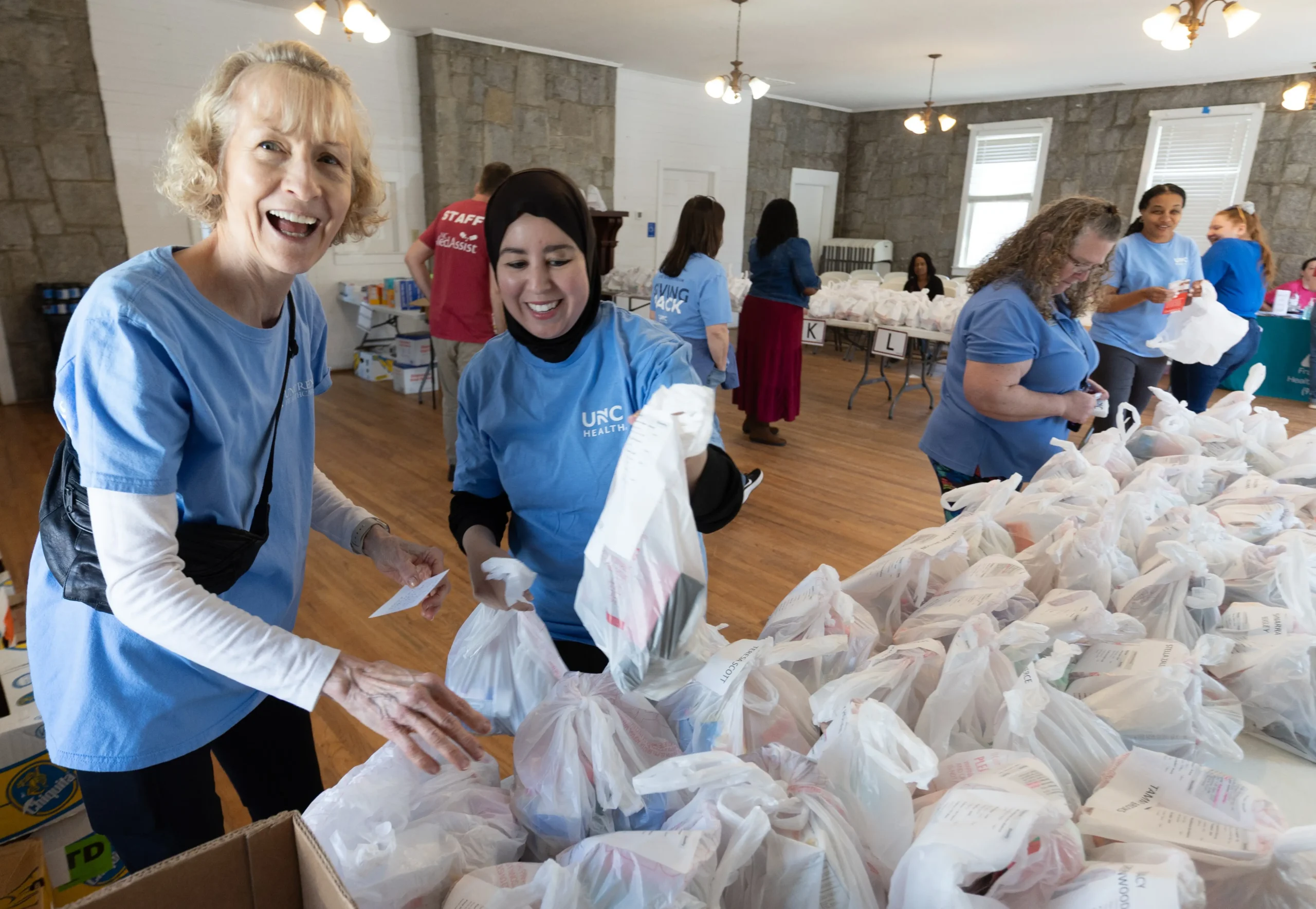 UNC Health volunteers assemble and organize care packages during a community outreach event supporting local families and individuals in need of statewide healthcare philanthropy