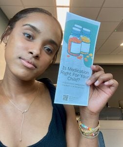 Kenan Primary Care Medical Scholar Mya Webb and the brochure she created as part of her summer internship project