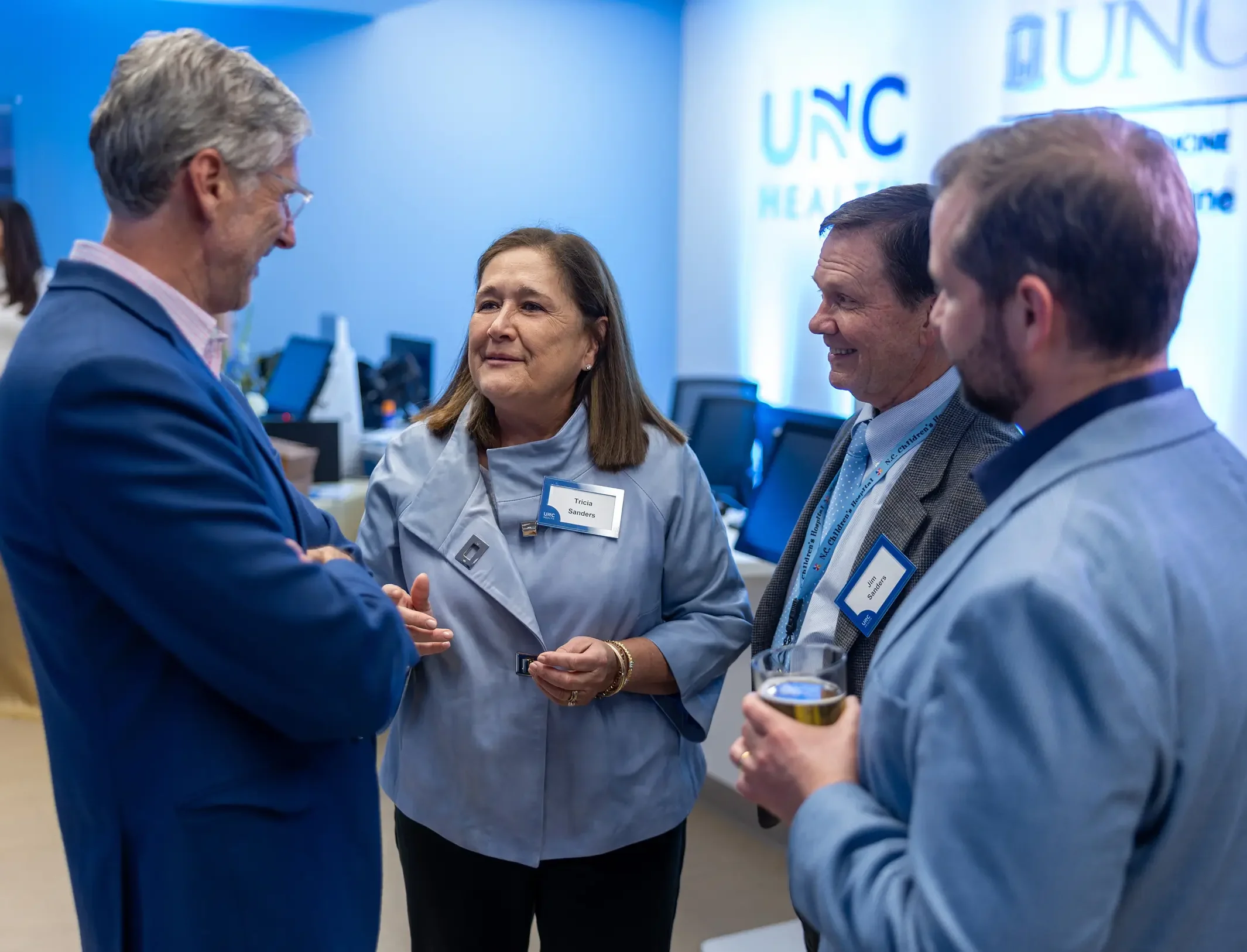 Healthcare professionals engaged in conversation during a UNC Health event.