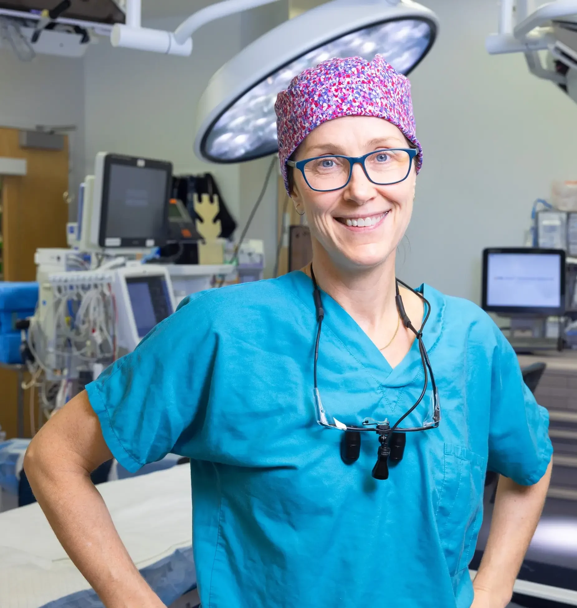 Hand surgeon in surgical scrubs and cap standing confidently in an surgical suite funded through planned giving