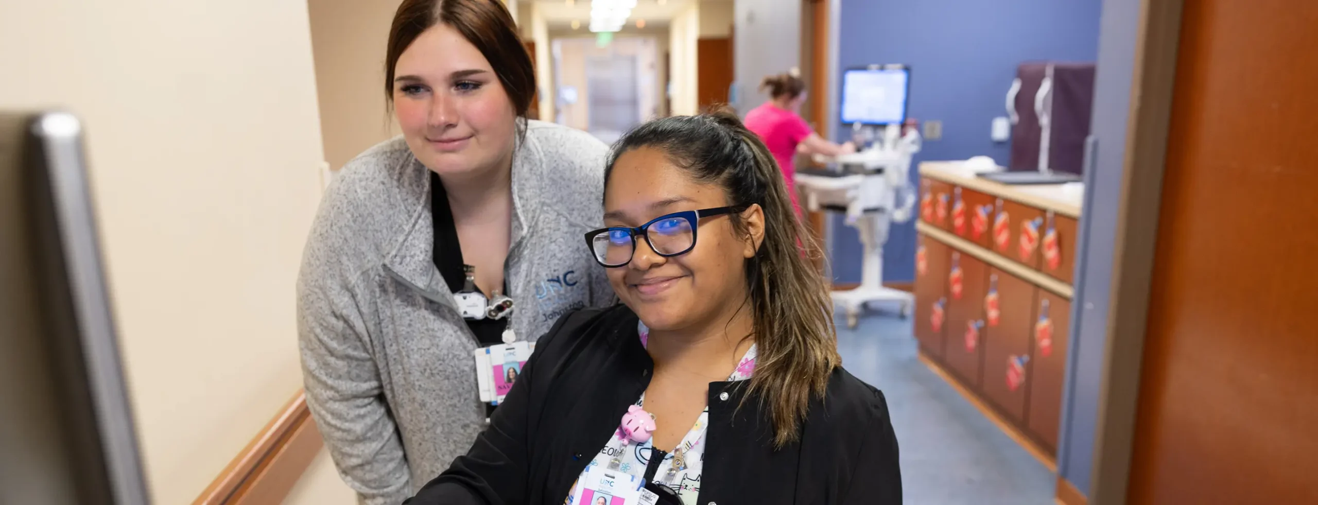 Two healthcare professionals at an intake desk ready to assist potential donors and corporate philanthropists interested in supporting unc research.