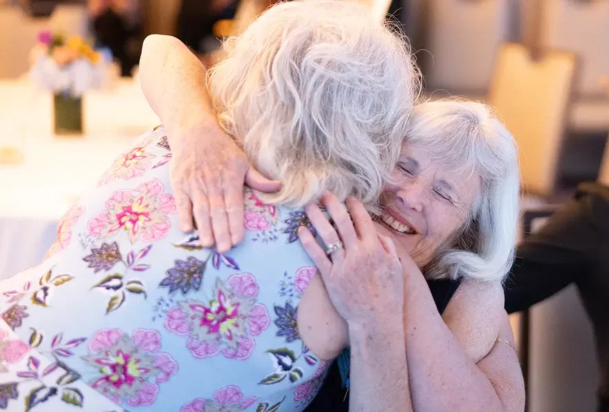 A cancer research donor and a UNC patient embrace, highlighting the impact of healthcare philanthropy and research support.