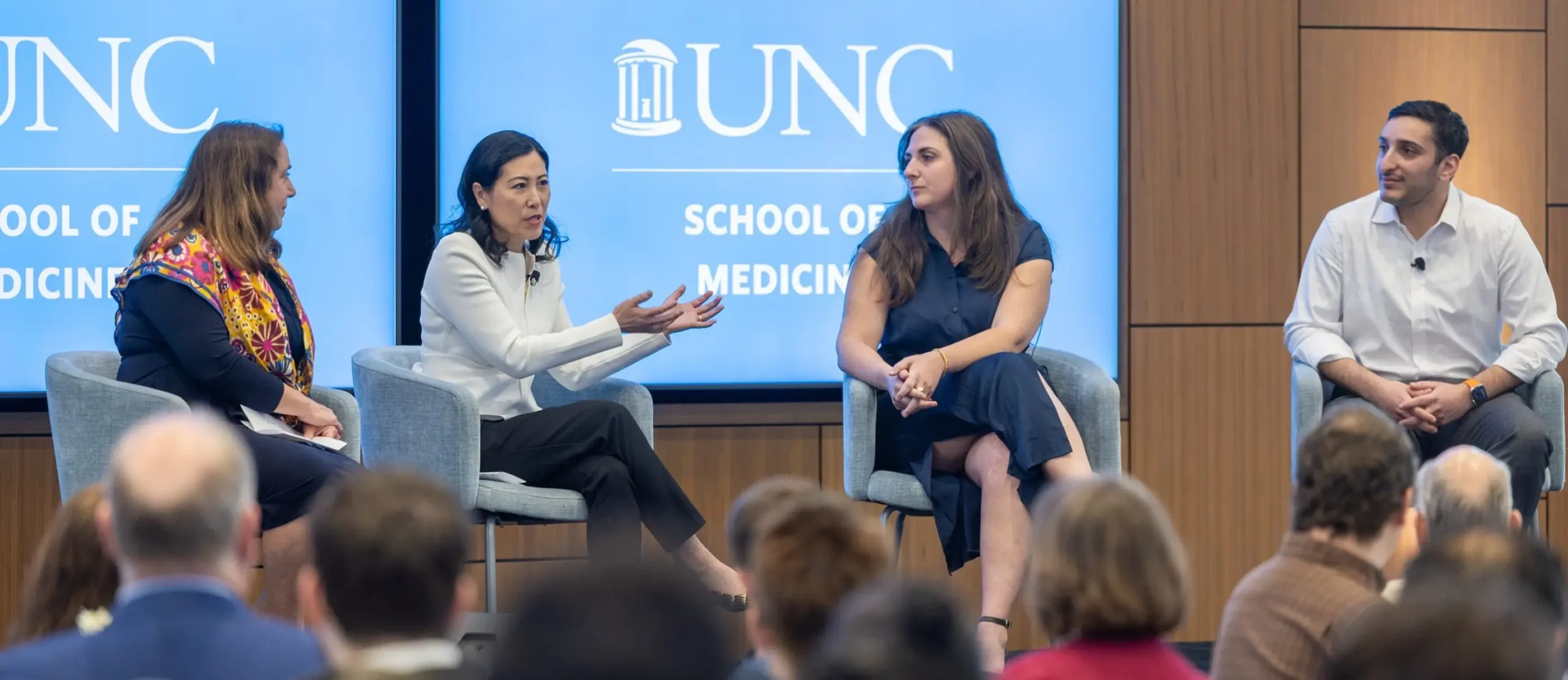 Healthcare professionals from UNC Health Foundation participating in a panel discussion at a medical conference, sharing how UNC research funding is impacting medicine.