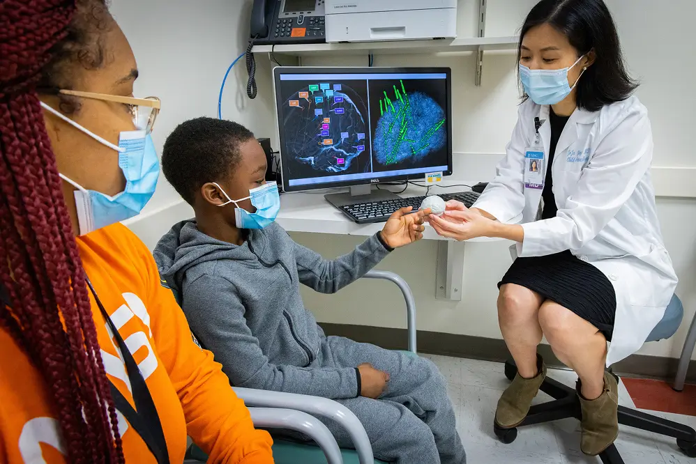 Pediatric patient meeting with a UNC neuroscience researcher in a lab funded by a memorial donation