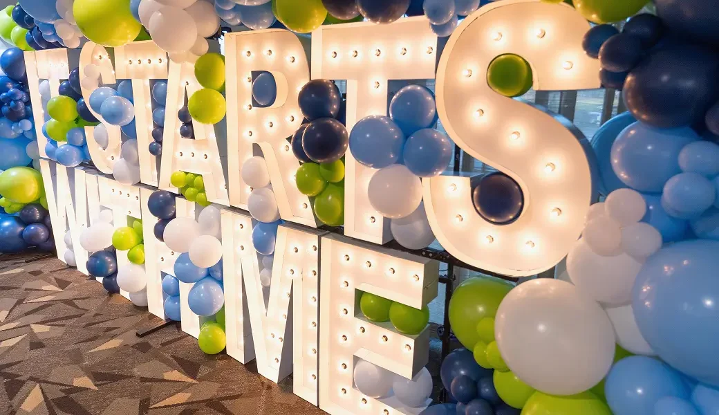 Illuminated “Staffs We Love” display surrounded by colorful balloons at a healthcare staff appreciation event, reminding donors that their charitable gifts, gifts of legacy, employee donations, and memorial donations have a lasting impact on healthcare innovation