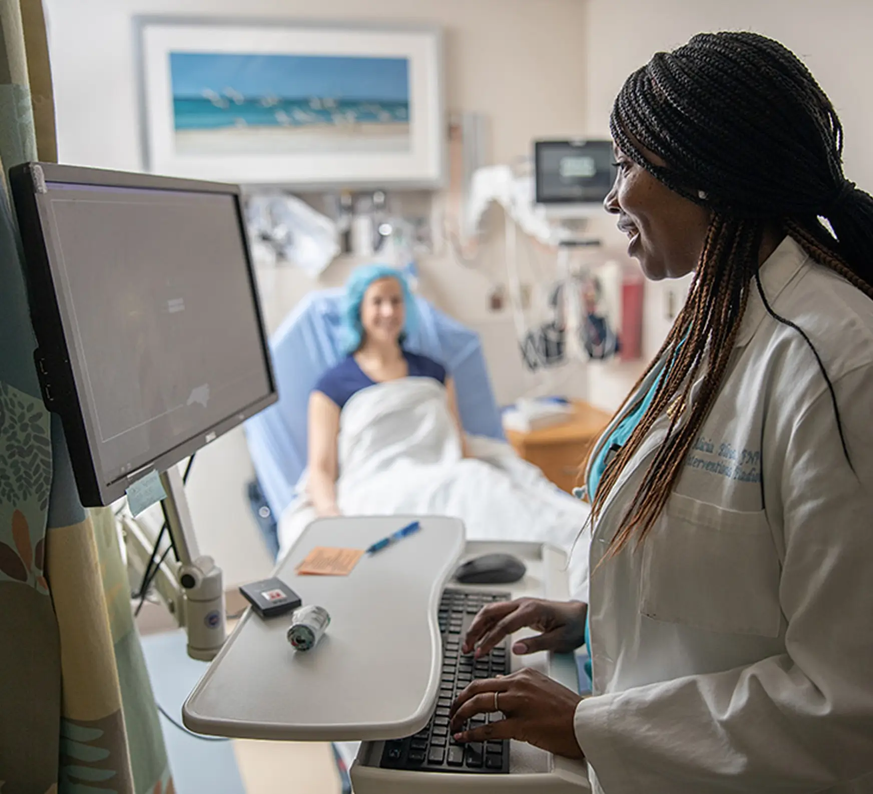 Doctor using applying women's health research made possible by UNC Health Foundation while a patient rests in a hospital room.