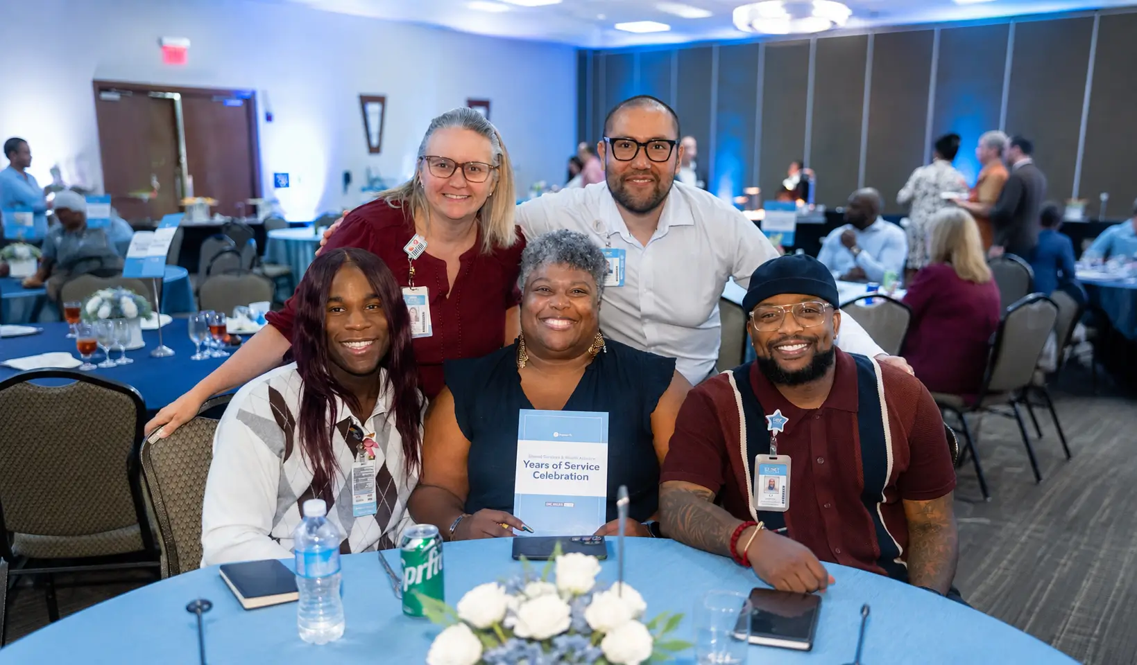 Five healthcare professionals smiling together at a Years of Service celebration event.