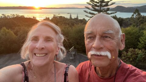 A Leslie Morrow, PhD, and Michael Lish, MD, stand in front of a lake at sunset