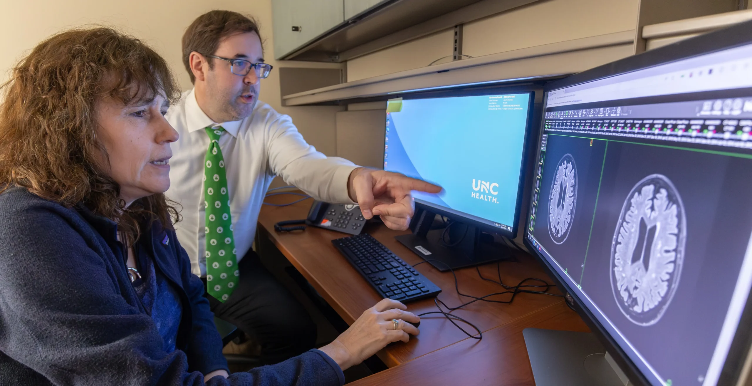 UNC Health medical professionals review a brain MRI scan on computer monitors and apply the latest neuroscience research during a clinical consultation.
