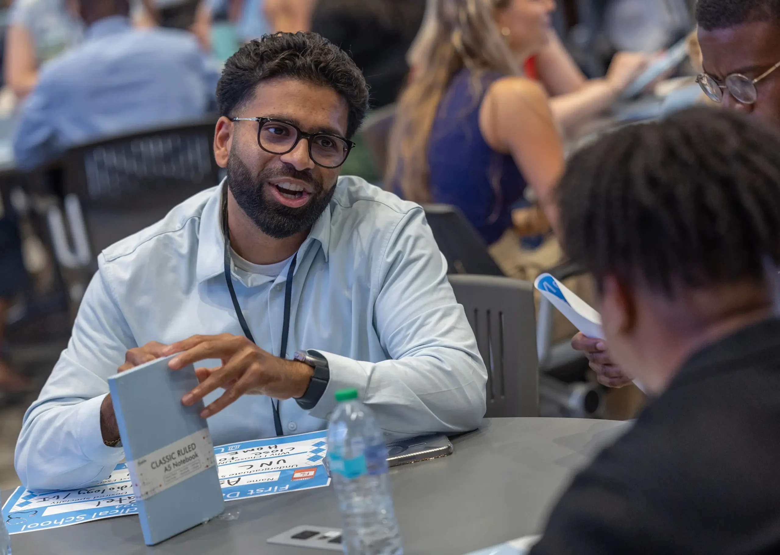 Healthcare professional speaking with another attendee during a group event.