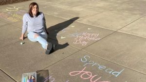 Nicole Proctor poses with some of her chalk art at UNC REX.