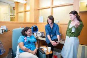 Lauren Lux, MSW, and Catherine Swift, LCWSA, chat with a patient.