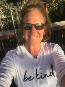Patti Brenton smiling in a shirt that says "be kind"
